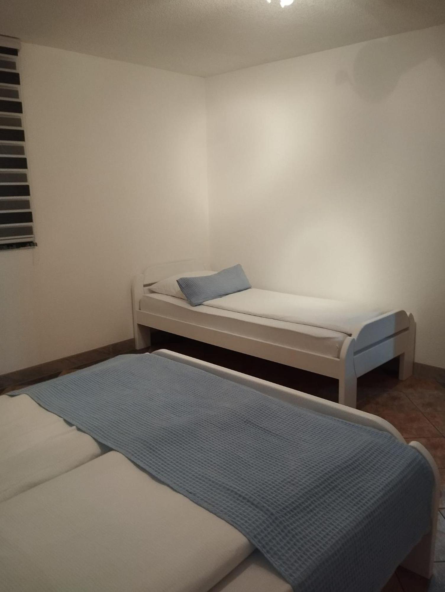 Spavaća soba s većim krevetom i krevetom za jednu osobu.