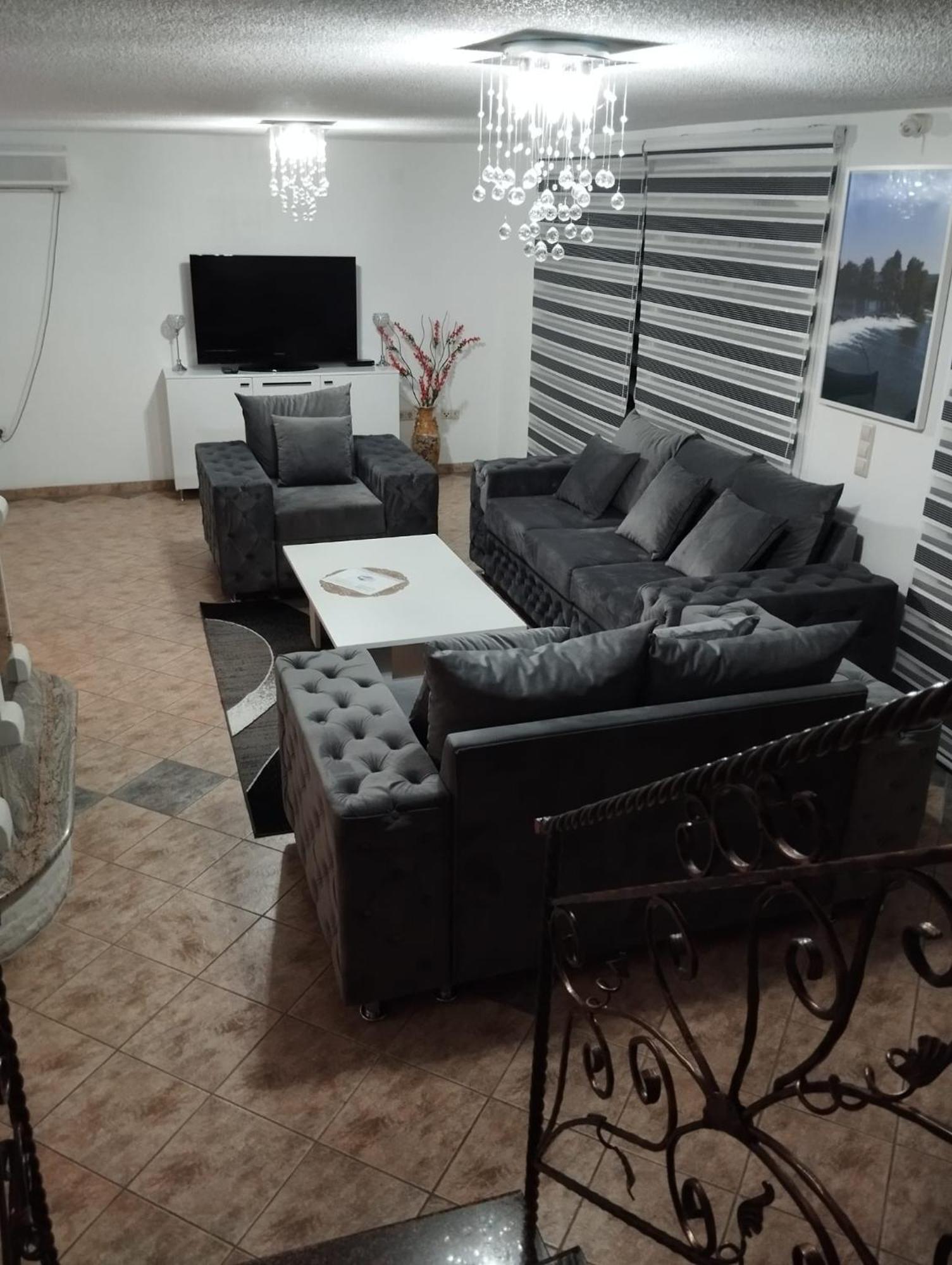 Dnevni boravak sa sofama i televizorom.