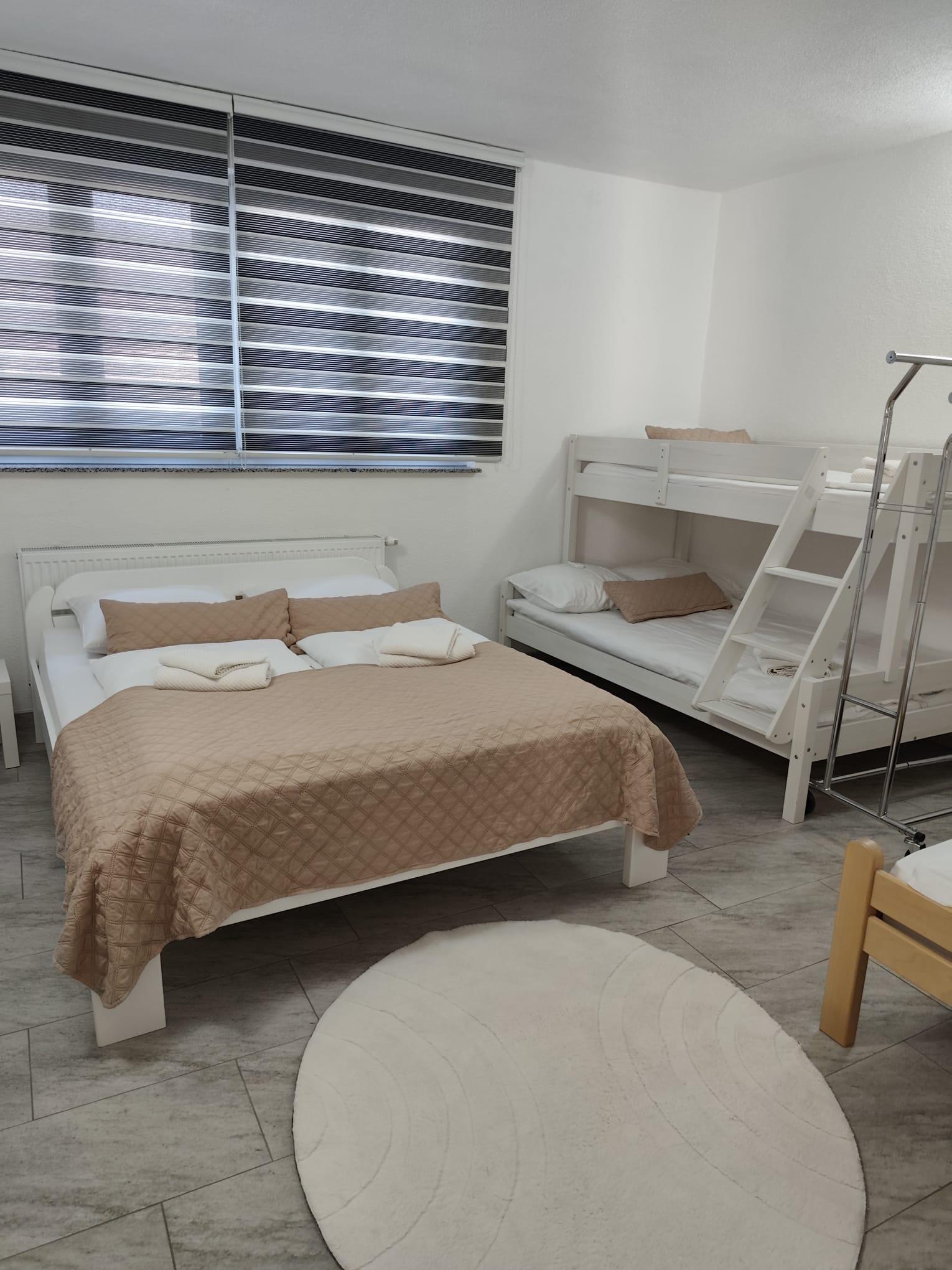Schlafzimmer mit Doppelbett, Etagenbett und einem weiteren Einzelbett.